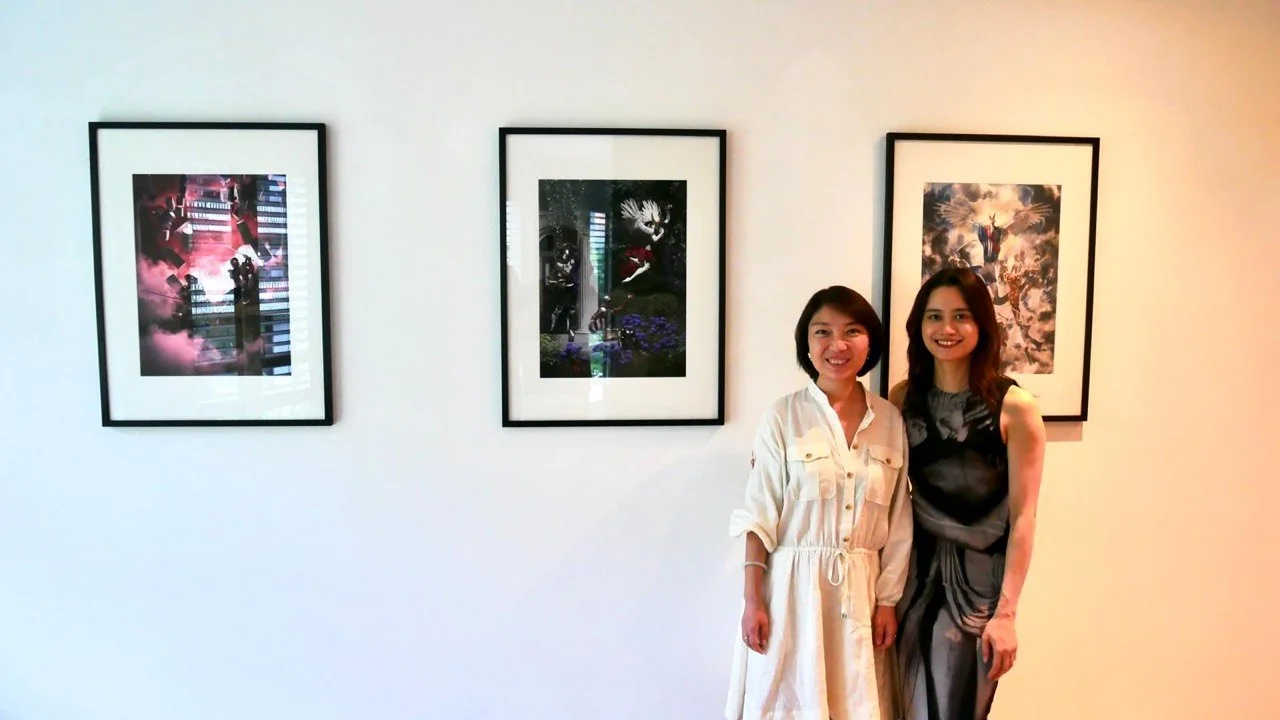 The three framed works of the triptych on a white gallery wall, two visitors in front